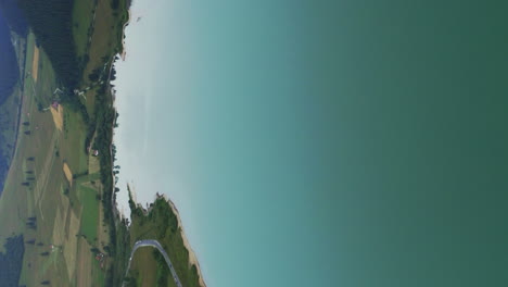 Vertical-format-aerial-clip-above-large-reservoir-behind-Frumoasa-Dam,-Romania