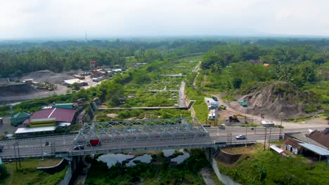 Kali-Putih-River-bridge-and-dry-riverbed-overgrown-by-greenery-aerial-view