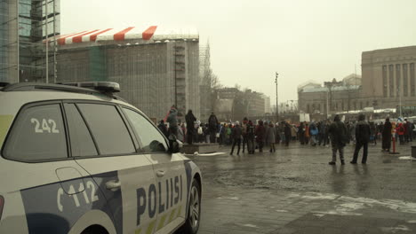 Weitwinkelaufnahme-Eines-Polizeiautos-Vor-Der-Versammlung-Der-Demonstranten-In-Helsinki