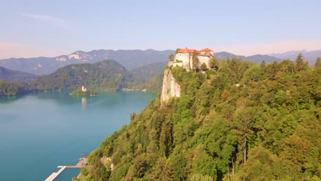 Aerial-dolly-in-towards-Bled-Castle-high-above-Bled-Lake-in-Northern-Slovenia