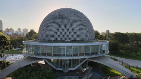 Aerial-dolly-in-over-Galileo-Galilei-Planetarium-dome-in-Palermo-Woods-at-daytime,-Buenos-Aires