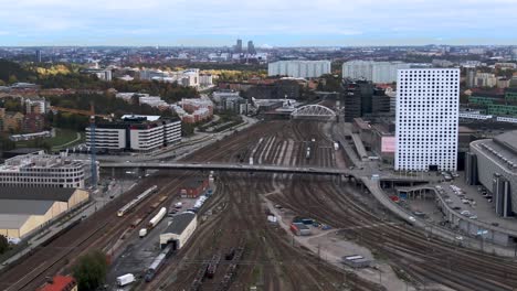Aerial-Panning-Shot-Over-Solna-Rail-Yard-And-View-Of-Stockholm,-Sweden