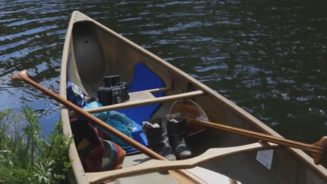 A-canoe-sits-calmly-on-a-river-shore