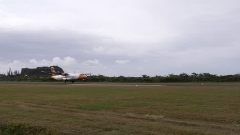 Air-Calédonie-propeller-airplane-landing-on-Maré-Island,-New-Caledonia