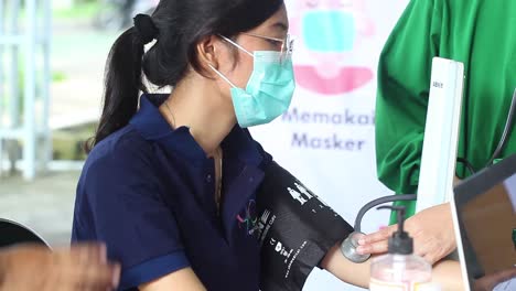 Yogyakarta,-Indonesien-–-15.-Februar-2021:-Weibliches-Gesundheitspersonal-In-Einem-Krankenhaus-Wird-Vor-Der-Injektion-Des-Corona-Virus-Impfstoffs-Auf-Seinen-Blutdruck-überprüft