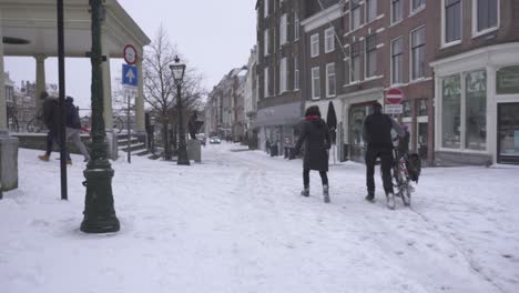 Leiden-streets-in-winter-snow,-cold-Netherlands-winter,-people-walking-in-city