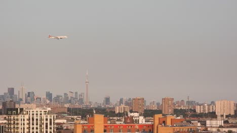 Wide-shot-of-Passenger-Airplane-Flying-over-Buildings-Approaching-Toronto-International-Airport
