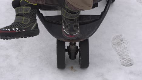 The-feet-of-a-young-boy-that-is-moving-on-a-stroller