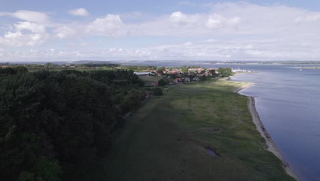 Aerial-View-of-a-Coastline-and-a-Small-Town-in-Denmark---Dolly-Shot