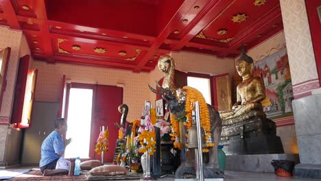 Ein-Mann-Sitzt-Auf-Dem-Boden-Und-Betet-Vor-Dem-Großen-Goldenen-Buddha