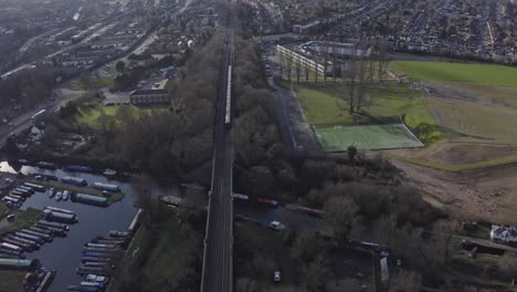 cinematic-pan-down-drone-shot-of-London-Metropolitan-line-train-in-suburban-UK-Watford