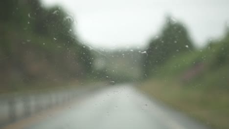 Windscreen-wiper-wiping-car-glass-in-a-rainy-day-on-the-road,-slow-motion