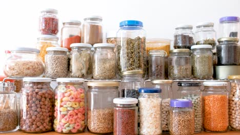 Jars-of-spices-and-cereals-on-kitchen-counter,-truck-shot
