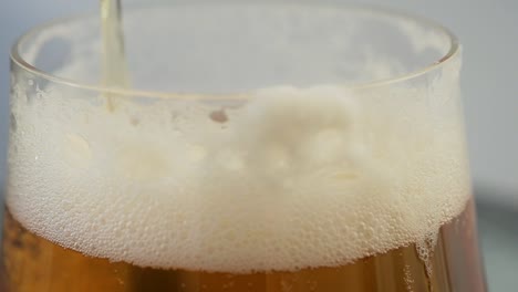 Slow-motion-close-up-of-a-lager-beer-foaming-up-after-pour-in-glass