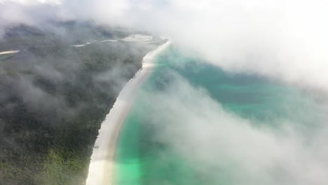 Peaceful-morning-beach-aerial-in-low-cloud,-QLD-Australia-coast