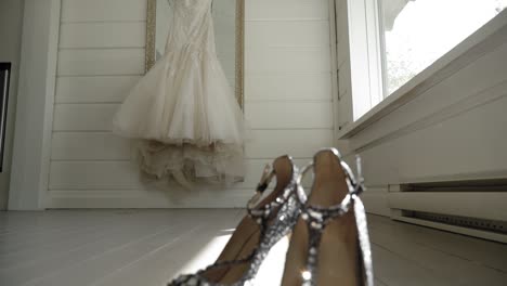 Reveal-of-a-pair-of-crystal-high-heals-from-the-view-of-a-elegant-wedding-dress-in-a-white-room-at-Le-Belvédère-in-Wakefield,-Quebec,-Canada