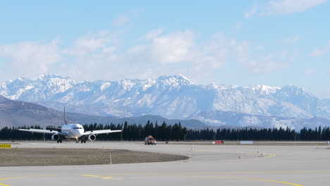Airbus-A320-following-car-on-taxiway-in-front-of-Montenegro-mountains