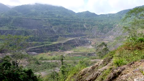 Looking-inside-the-huge-cooper-and-gold-mine-pit-at-Panguna-Mine-on-remote-tropical-island,-Autonomous-Region-of-Bougainville,-Papua-New-Guinea