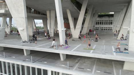 Orbiting-aerial-of-Tae-Bo-exercise-class-in-open-air-parking-garage