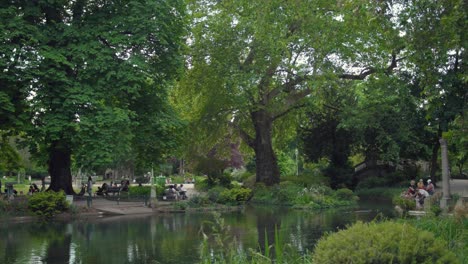 Panning-across-Parc-Monceau-with-beautiful-trees-and-lake-or-pond-on-summer-day-in-Paris,-France