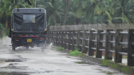 Südindische-Autorikscha,-Die-Während-Der-Regenzeit-Auf-Einer-Brücke-Vorbeifährt-–-Rückwinkel