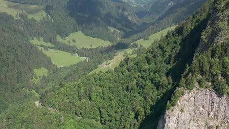 Aerial-view-of-green-valley,-drone-pulling-back-and-revealing-mesmerizing-green-mountains