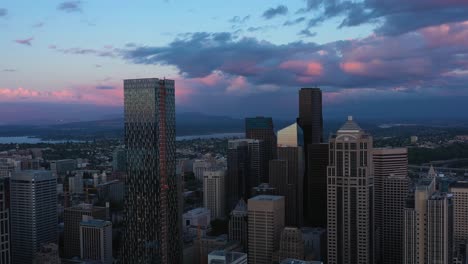Aerial-shot-pulling-away-from-Seattle-vast-downtown-skyline-during-a-cool-pink-sunset