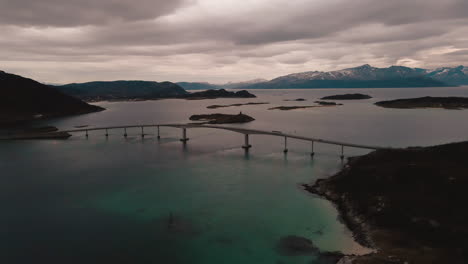 Cielo-Rosa-épico-Durante-La-Puesta-De-Sol-ártica-Mientras-El-Dron-Muestra-El-Puente-Sommaroy-Sobre-El-Océano,-Noruega