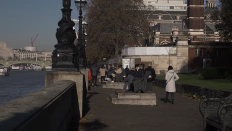 People-walking-along-Albert-embankment-path-along-the-river-Thames-during-the-day