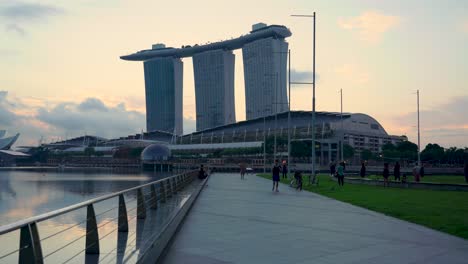People-jog,-brisk-walk-and-do-yoga-outdoors-at-The-Promontory,-Marina-Bay,-Singapore