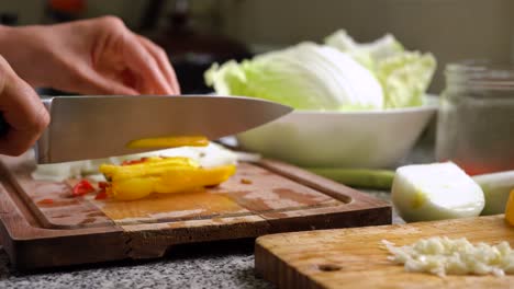 Hands-Cutting-Yellow-Bell-Pepper-Into-Strips-In-The-Kitchen