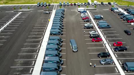 Amazon-vans-in-the-parking-lot-of-an-Amazon-warehouse---aerial-drone