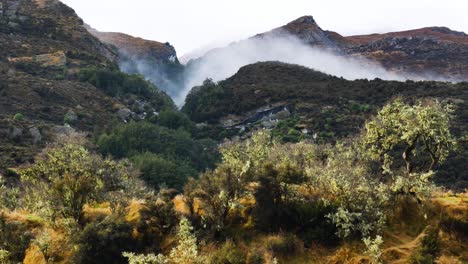 Beautiful-scenery-of-mountains,plants-and-mystical-fog-rising-up-from-the-valley-during-sunlight---Autumn-day-during-hike-at-Rees-Valley,New-Zealand