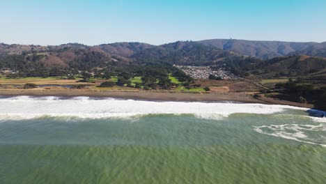 Aerial-View-of-Mori-point-beach-Coastal-cliffs-with-turquoise-waves-hitting-the-shore,-drone-pan-left-shot