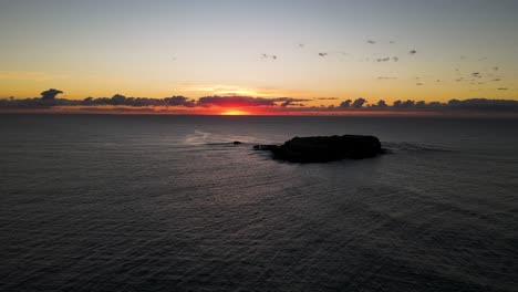 Bunter-Sonnenaufgang-Am-Morgen-über-Einem-Ruhigen-Wintermeer,-Eingerahmt-Von-Der-Silhouette-Einer-Meeresparkinsel
