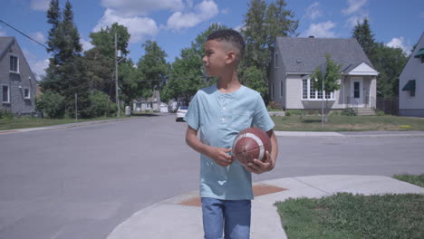 Junger-Afroamerikanischer-Junge,-Der-Mit-Fußball-Auf-Der-Straße-Läuft