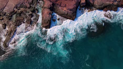 Aerial-drone-top-down-of-waves-breaking-against-rocks-in-Kalbarri-Western-Australia