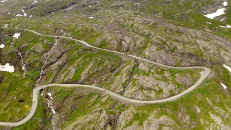 Vista-Aérea-De-Un-Vehículo-Conduciendo-Por-El-Estrecho-Paso-De-Montaña-En-Geiranger,-Noruega