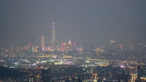 Distance-View-of-Day-to-Night-Time-Lapse-of-Taipei-101-with-air-pollution-thick-smog,-overlooking-busy-Taipei-City-Taiwan