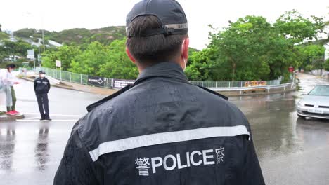 Un-Oficial-De-Policía-Hace-Guardia-Bajo-La-Lluvia-En-Hong-Kong