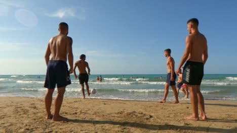 Chicos-Jugando-Fútbol-Playa-En-Vacaciones-De-Verano