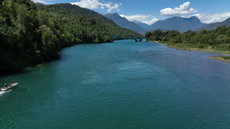 Luftaufnahme-Eines-Schnellbootes-Entlang-Des-Puelo-Flusses,-Das-Sich-Einer-Niedrigen-Brücke-In-Chile,-Seengebiet,-Nähert