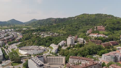 Living-district-with-apartment-buildings-and-forestry-hills-of-San-Sebastian,-aerial-drone-view