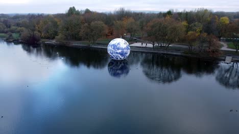 Luke-Jarram-floating-earth-art-exhibit-aerial-view-Pennington-flash-lake-nature-park-descending-push-in