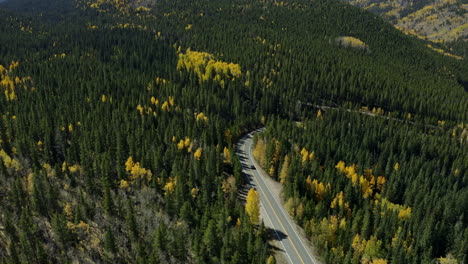 Aerial-shot-over-stunning-mountain-highway-with-fall-forest-colors,-4K