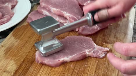 Zartmachen-Von-Schweinefleischstücken-Mit-Dem-Fleischhammer-Werkzeug-–-Mit-Dem-Fleischklopfer-Fleischzartmacher-Zur-Zubereitung-Von-Schweinefleischplatten-Und-Zum-Würzen-Mit-Salz-Für-Das-Rezept-Für-Schweineschnitzel-Zu-Hause-In-Zeitlupe-In-Der-Küche