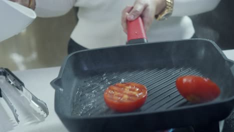 Der-Koch-Flambiert-Tomaten-In-Der-Grillpfanne,-Indem-Er-Alkohol-Einschenkt