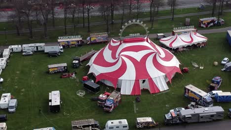 Planet-circus-daredevil-entertainment-colourful-swirl-tent-and-caravan-trailer-ring-aerial-view-zooming-in