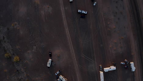 Aerial-top-down-view-of-motorhomes-parked-in-the-desert-at-golden-hour