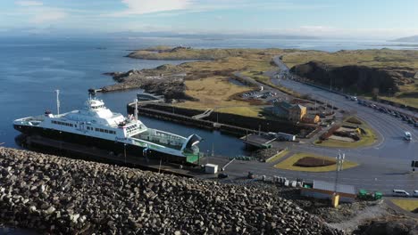 Beautiful-aerial-of-ferry-Runefjord-wating-to-load-cars-in-Mortavika-port---Sunny-day-with-ocean-background-and-revealing-road-with-cars-waiting-in-line
